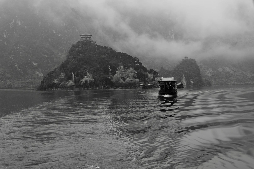 一个小船在靠近山脉的水域中穿越