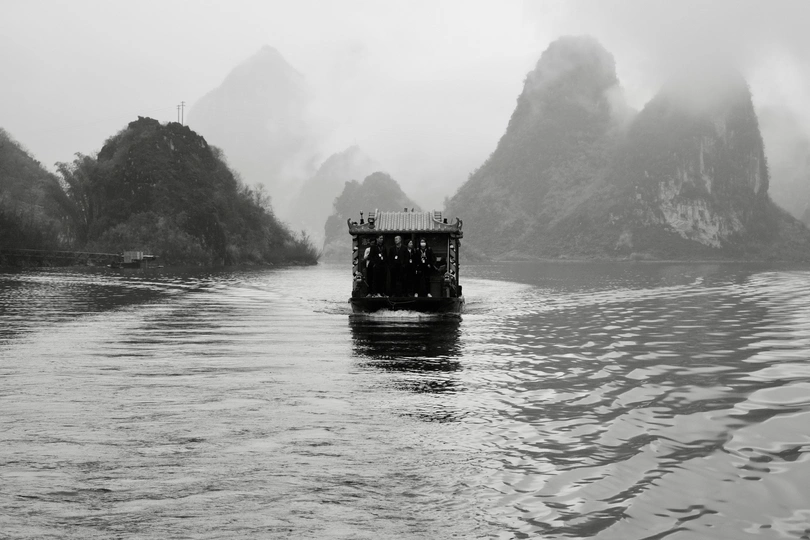 一个小船在河上漂浮 背景是大山