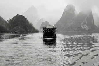 一个小船在河上漂浮 背景是大山