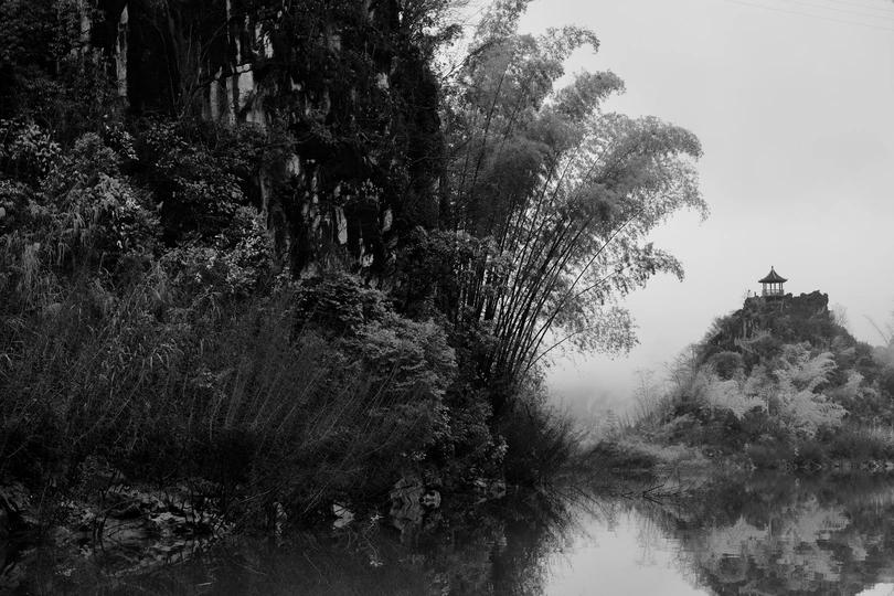 一条小河 有树和一所房子。