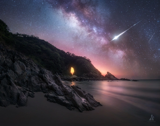 夜晚海洋边岩石海滩 星空在天空中。