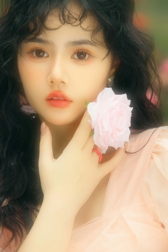 一位美丽的年轻女子手持一朵粉色花