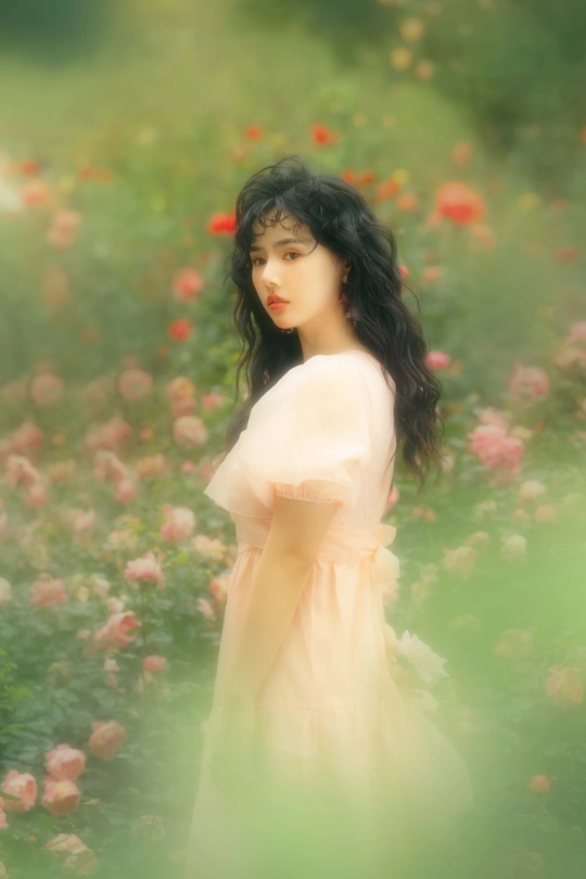 一位穿着黄色连衣裙的年轻女子站在花丛中
