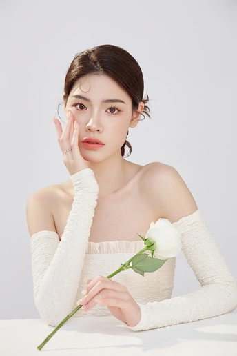 美丽的年轻女子 皮肤白皙 手持白色玫瑰花。