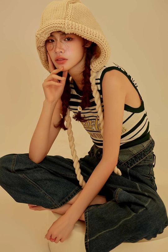 一位穿着条纹工作服和帽子坐在椅子上的年轻女子