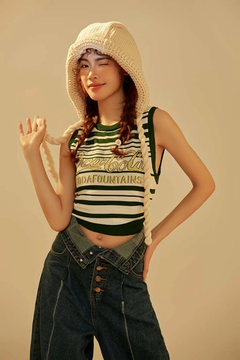 一位穿着条纹衬衫、牛仔裤和帽子的小个子年轻女子