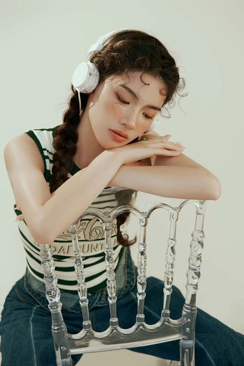 一位年轻女子坐在白色椅子上摆姿势