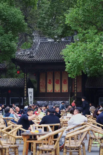 大量人群坐在户外桌椅上