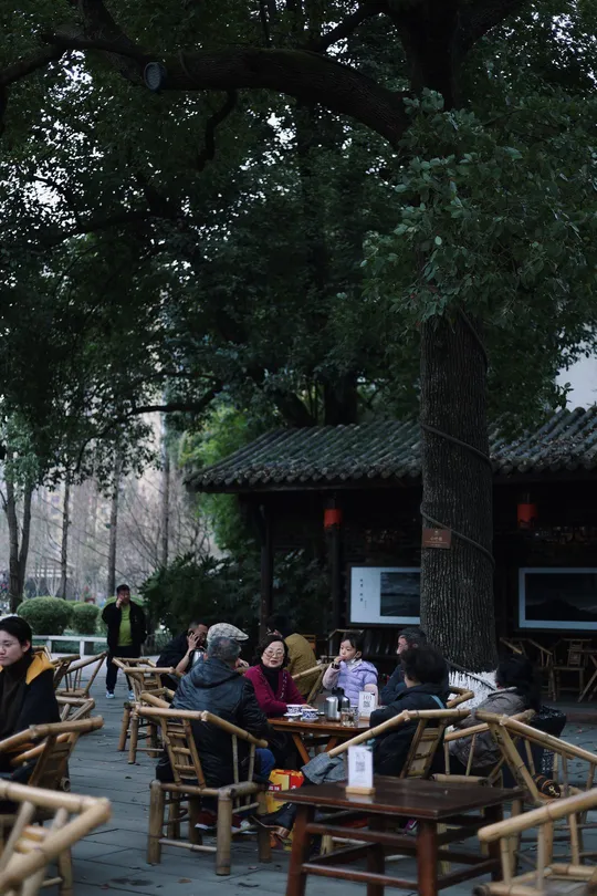 户外露台 有许多桌子和椅子 还有人。