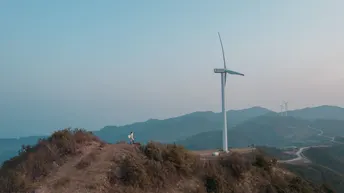 站在山顶上的一名男子正在看着风车