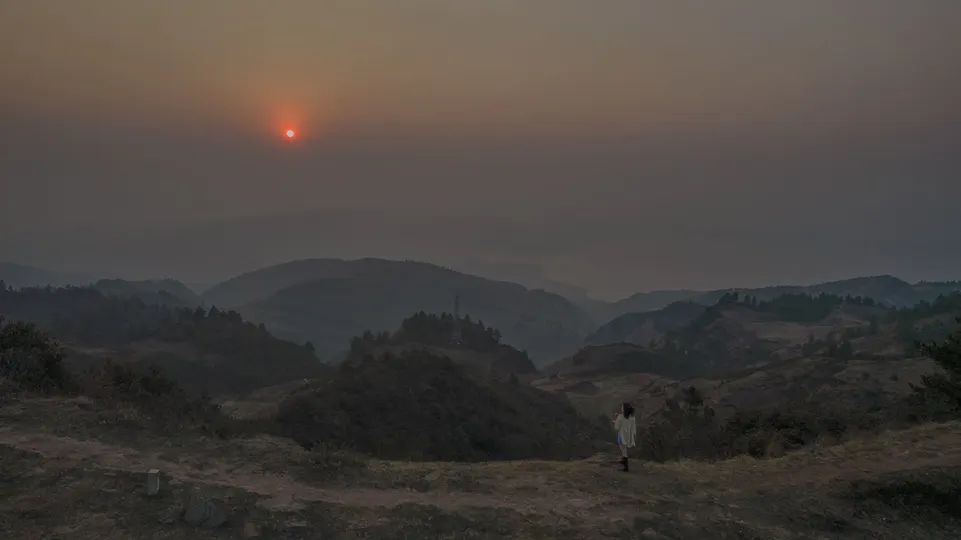 日落或日出时 山谷上有人站在山顶 太阳在天空中落下。