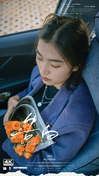 一个年轻女子坐在汽车的后座 手里拿着橙色玫瑰。