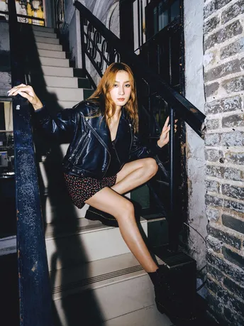 一个穿黑色皮夹克的女人坐在楼梯的台阶上
