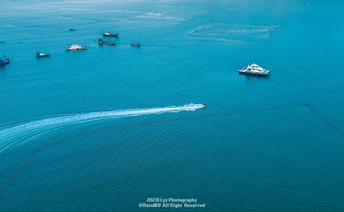 一群小船在海洋的蓝色水域中漂浮