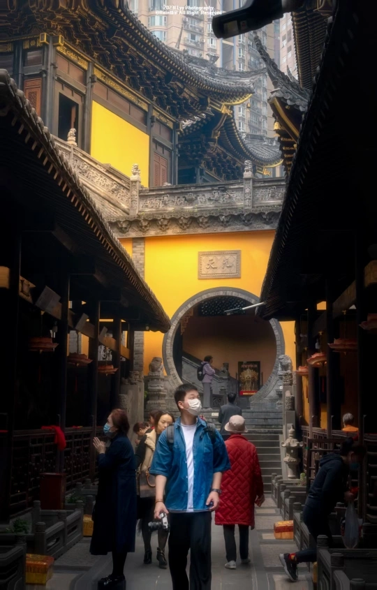 一个戴口罩的男人走在老城区的一条小巷子里