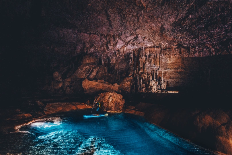 一个人在一片大水域中的船上被照亮了。