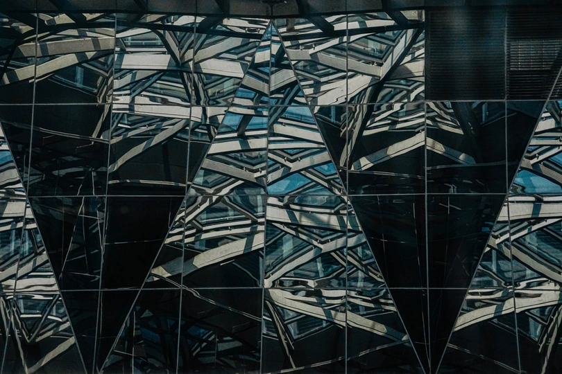 建筑物的倒影在另一栋建筑物的玻璃上反射 另一栋建筑物的窗户上也有反射。