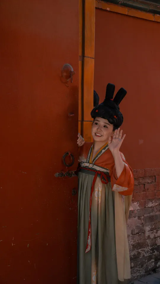 一个小男孩或小女孩穿着传统服装站在门前