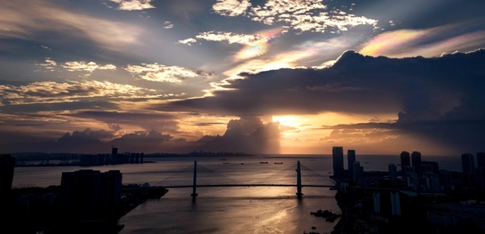 城市上空的日落 桥跨水面 天空中云朵飘过。