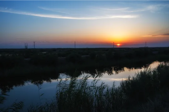 晨曦或夕阳洒在水面上的景象 太阳在地平线上落下