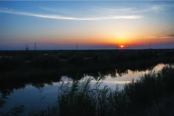 晨曦或夕阳洒在水面上的景象 太阳在地平线上落下