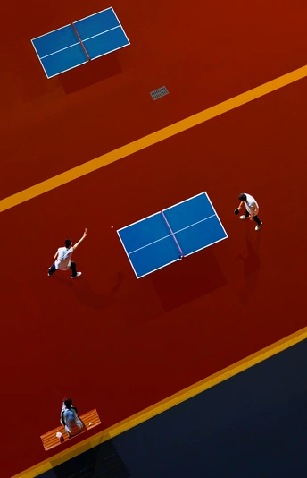 一些人正在一个蓝色和红色的网球场打网球。