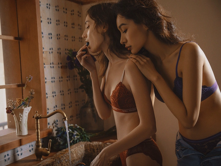 一个美丽的年轻女子穿着比基尼站在浴室水槽旁边