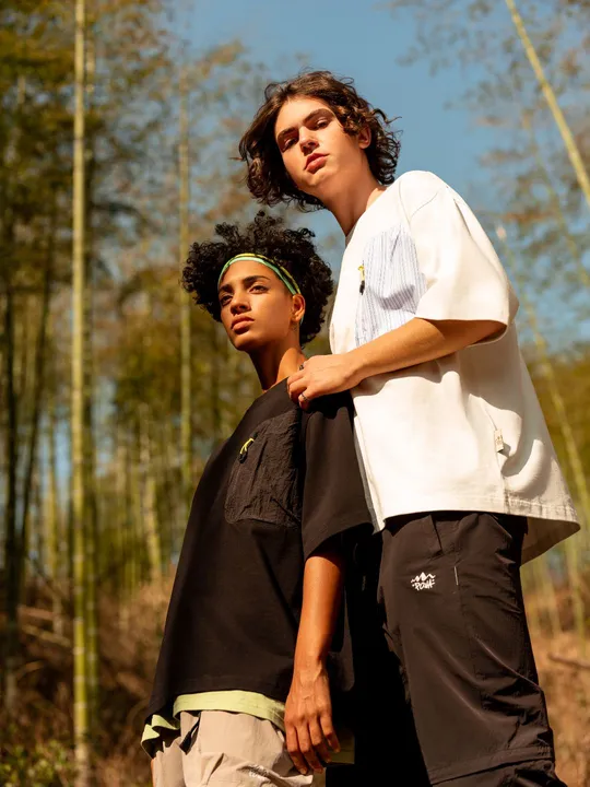 一个年轻男子站在森林里 旁边有一个年轻男孩。