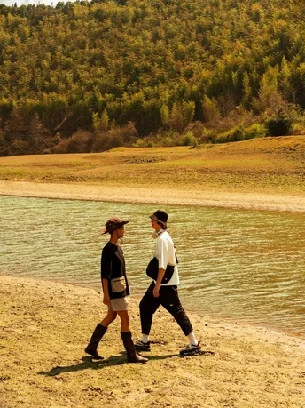 一位年轻男孩和一位女士在湖边或河边散步