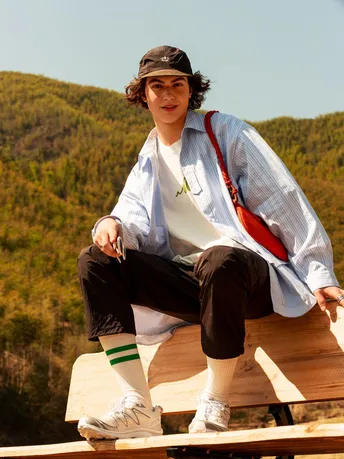 一个年轻女子坐在木凳上戴着帽子