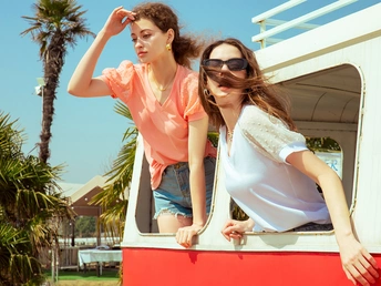 两年轻女子站在一辆红色的货车里