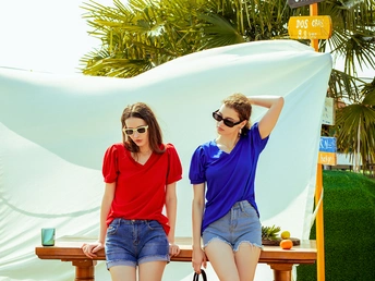 一些年轻女性站在一把白色雨伞旁边