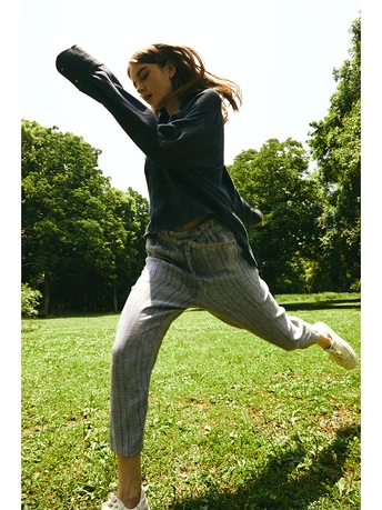 一个年轻女子在一个草地上扔飞盘 而另一个人站在她身后的草地上。