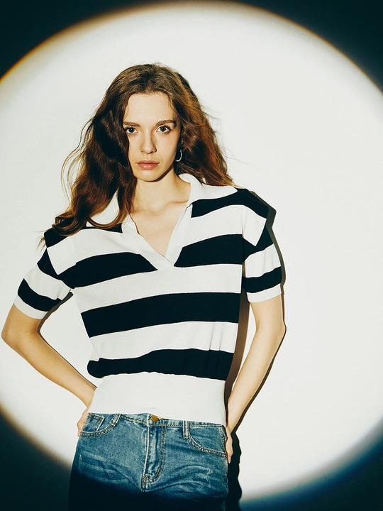 一条纹的衬衫 黑色白色条纹的上衣和牛仔裤 一个年轻的女子