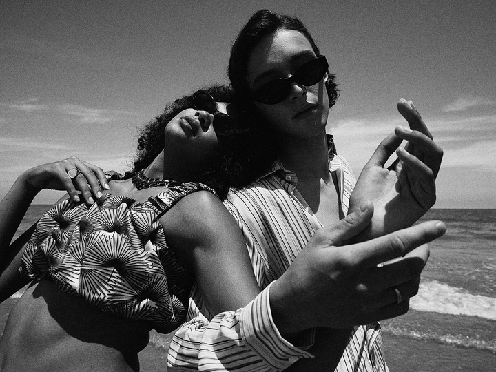 背景是海洋 沙滩上有黑人和白人男女