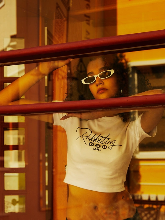 一位戴白色眼镜的年轻女子站在一扇门前