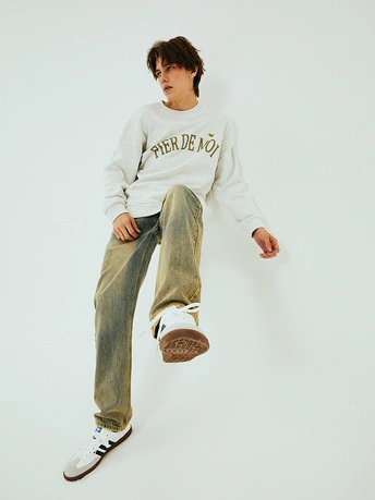 一个穿白色汗衫的男孩在滑板 对着墙