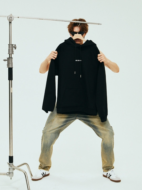 一个穿着黑色衬衫的年轻人 拿着话筒对着嘴