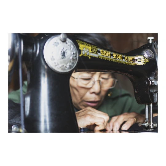 一位老人在缝纫机上工作