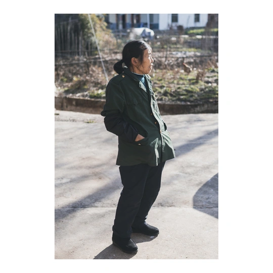 一位穿着绿色夹克在街上的女人