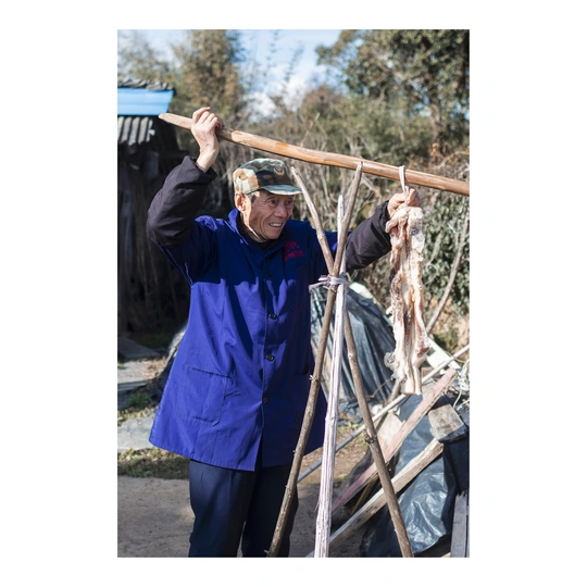 一个人站在梯子旁边 头上顶着木棍