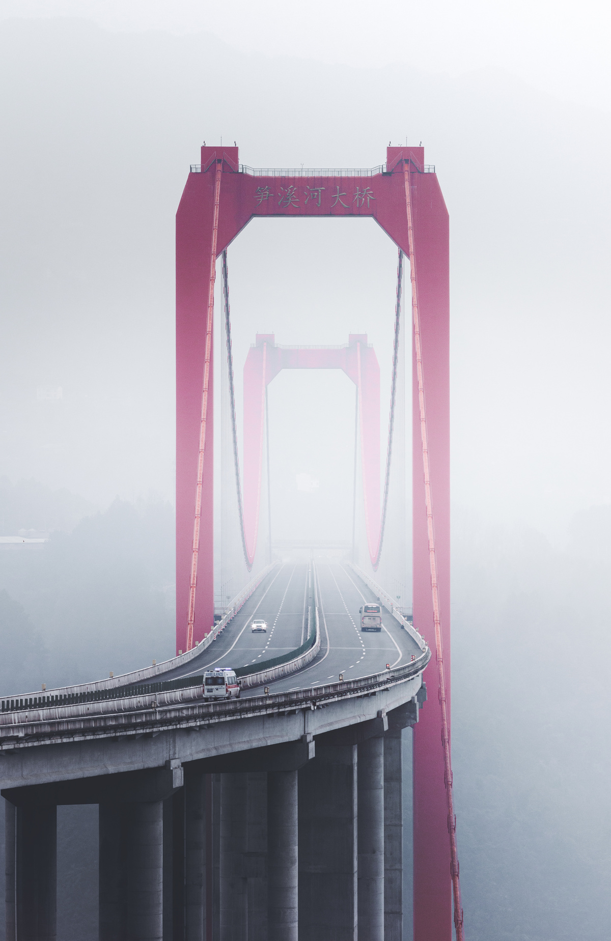 雾气缭绕的桥上 背景中有一座红色的桥。