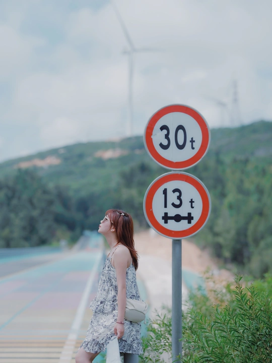 站在一个有数字标志的桥上的年轻女子