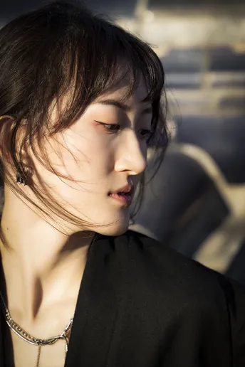 一位穿着黑色衣服的年轻女子被阳光照亮