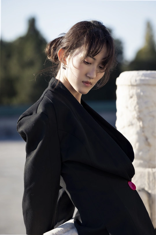 一位穿着黑色外套的年轻女子站在外面