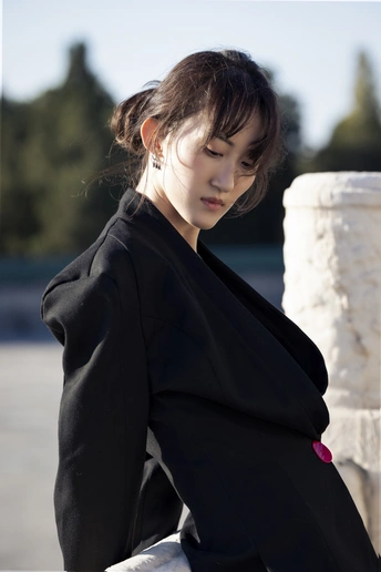 一位穿着黑色外套的年轻女子站在外面