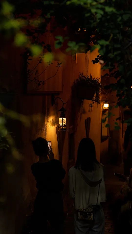 夜晚 一两个人在黑暗的巷子里拿着灯笼走。