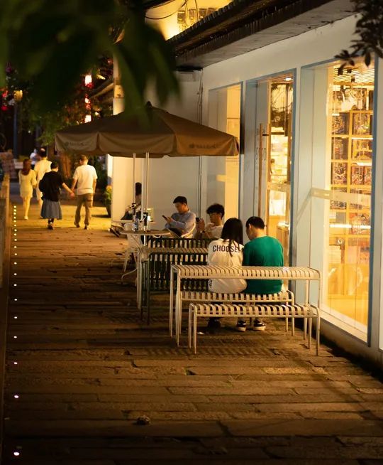 夜晚餐厅外的长椅上坐着的人们