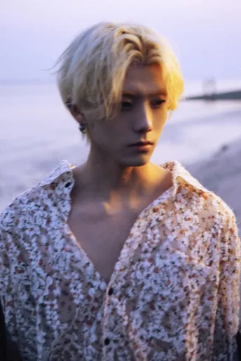 一位金发女子站在海滩上