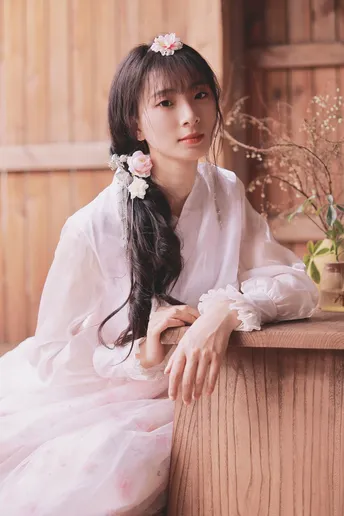 一位美丽的年轻女子穿着一件白色连衣裙 头戴花饰。